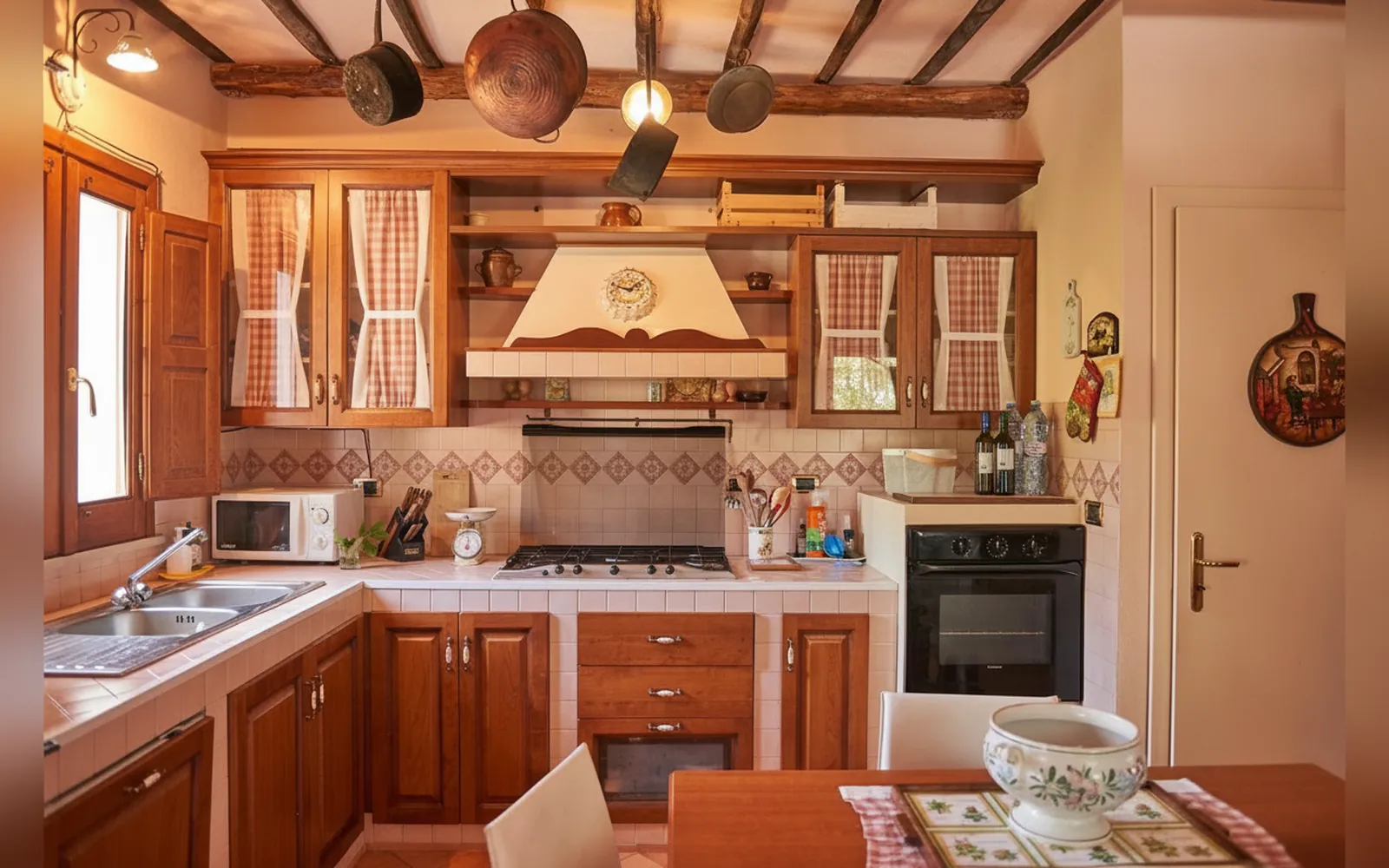 La cucina in legno con il piano cottura, il forno e le pentole in rame